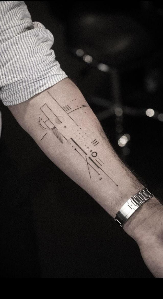 Tattoo artist creating an intricate fine line design on a forearm