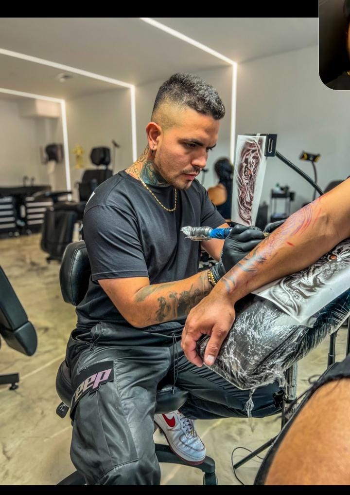 Tattoo artist inking a design with precision during a consultation session